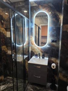 un bagno con lavandino e specchio di Green Baltic Portovo Comfort Apartment City Center Balcony a Danzica