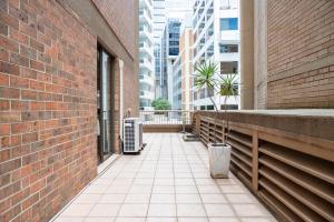 a walkway in a building with a brick wall at Spacious 1-bed flat in CENTRAL Sydney in Sydney
