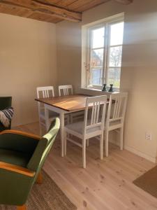 a dining room with a wooden table and chairs at Stuga i Maglehem in Degeberga