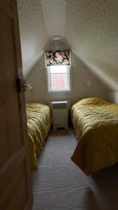 two beds in a small room with a window at Stuga i Maglehem in Degeberga