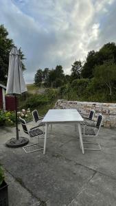 a white table with four chairs and an umbrella at Stuga i Maglehem in Degeberga +9 photos