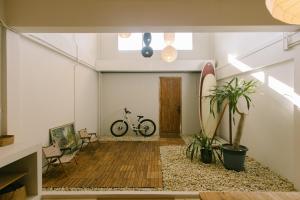 une chambre avec une planche de surf et un vélo dedans dans l'établissement PANI Place Khaolak, à Khao Lak