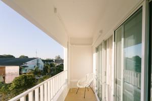 une chaise blanche assise sur le balcon d'une maison dans l'établissement PANI Place Khaolak, à Khao Lak