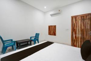 a room with two blue chairs and a table at Hotel O by OYO Radha Raman Guest House in Rait