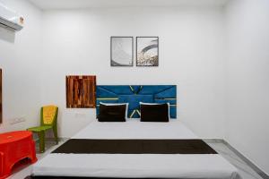 a bedroom with a large bed with a blue headboard at Hotel O by OYO Radha Raman Guest House in Rait
