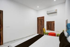 a room with a bed and chairs in it at Hotel O by OYO Radha Raman Guest House in Rait