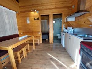 een keuken met een bank en een tafel in een hut bij Bungalows Nou Camping in Guingueta