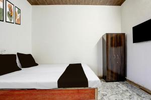 una camera da letto con un letto e una TV a parete di Hotel O Discus a Korādih Altre 22 foto