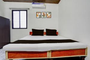 una camera da letto con un letto grande con cuscini neri di Hotel O Discus a Korādih