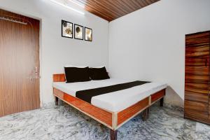 una camera da letto con un letto e una porta di legno di Hotel O Discus a Korādih