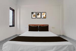 une chambre blanche avec un grand lit dedans dans l'établissement Hotel O THAIBA RESIDENCY, à Kuttyādi 28 autres photos