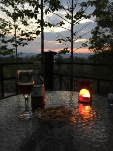 uma mesa com um copo de vinho e uma vela em Baan Rai Phufah Resort Chiangrai em Ban Pa Ruak