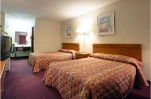 a hotel room with two beds and a television at Americas Best Value Inn Cartersville in Cartersville