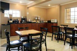 a restaurant with tables and chairs and a kitchen at Americas Best Value Inn Cartersville in Cartersville