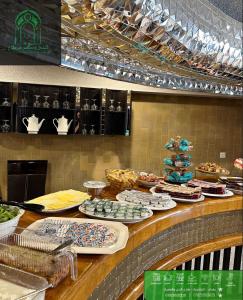 un bancone con molti piatti di cibo sopra. di Carthage suites hotel a Baghdād