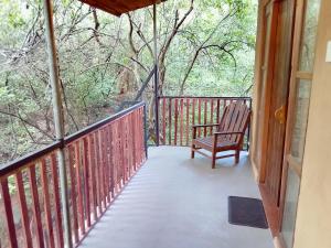a porch with a bench sitting on a deck at Peek & Pick Garden resort in Habarana