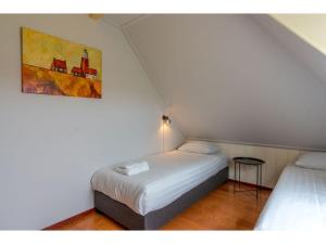 a bedroom with two beds and a painting on the wall at Lovely Holiday Home in Texel near Sea in Oost