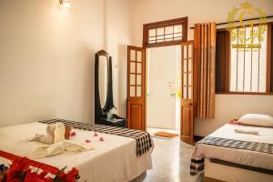 een slaapkamer met twee bedden en een spiegel bij Green Shade Resort & Haritha Sewana Hotel in Nallathanniya