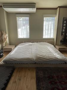 a large bed in a bedroom with two windows at hayama satoyado in Hayama