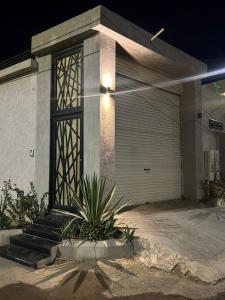 a house with a garage door and a plant at شاليهات ايفا 2 in Taif
