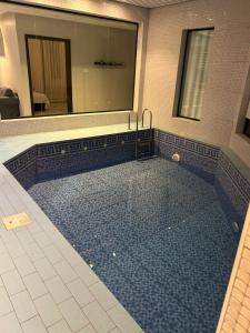 a large swimming pool in a bathroom with a mirror at شاليهات ايفا 2 in Taif