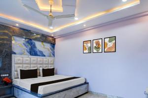 een slaapkamer met een bed en een schilderij aan de muur bij Hotel O RN Palace in Puri