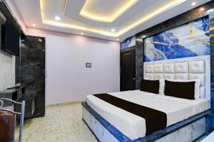 een slaapkamer met een bed met een schilderij aan de muur bij Hotel O RN Palace in Puri