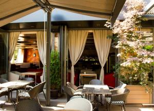 an outdoor restaurant with tables and chairs and flowers at Hotel Calipso Hotel in Sofia