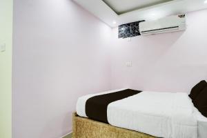 ein weißes Schlafzimmer mit einem Bett und einem Fenster in der Unterkunft Hotel O Royal Sangrila Inn in Dānāpur