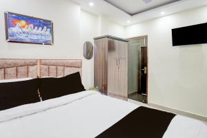 ein Schlafzimmer mit Bett und Flachbildfernseher in der Unterkunft Hotel O Royal Sangrila Inn in Dānāpur