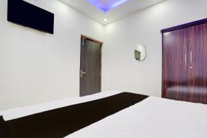 ein Schlafzimmer mit einem Bett und einem Fernseher an der Wand in der Unterkunft Hotel O Royal Sangrila Inn in Dānāpur