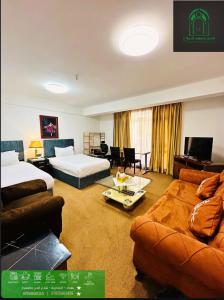 una camera d'albergo con due letti e un divano di Carthage suites hotel a Baghdād