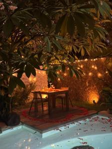 a picnic table under a tree with lights on it at Kuno Villas in Gili Trawangan