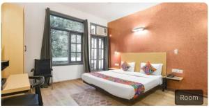 een hotelkamer met een bed, een bureau en een raam bij Hotel dev inn in Gurgaon