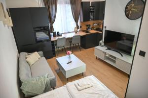 a living room with a couch and a tv and a table at Cozy Studio Heart in Banská Bystrica