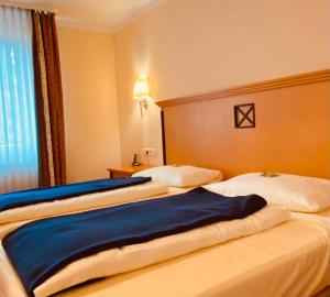 a hotel room with two beds and a window at Haus am Park in Bad Hersfeld