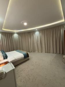 a bedroom with a bed in a room with curtains at فندف رياح الجزيرة في السليل in Ahl Ḩunaysh
