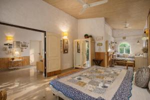 ein großes Schlafzimmer mit einem Bett und ein Wohnzimmer in der Unterkunft Elfreda, Vikramgad - 1BHK Villa - Pet Friendly in Zadapoli