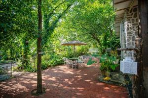 eine Terrasse mit Sonnenschirm und Tisch und Stühlen in der Unterkunft Elfreda, Vikramgad - 1BHK Villa - Pet Friendly in Zadapoli