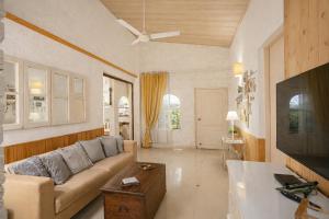 ein Wohnzimmer mit Sofa und Fernseher in der Unterkunft Elfreda, Vikramgad - 1BHK Villa - Pet Friendly in Zadapoli