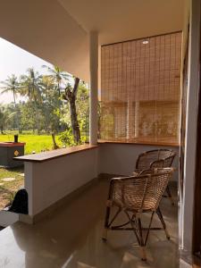 a wicker chair sitting in a room with a window at Bhoomi by Ostello in Varkala