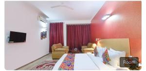 een hotelkamer met een bed en een rode muur bij Hotel dev inn in Gurgaon +14 foto's