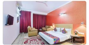 een hotelkamer met een groot bed en een woonkamer bij Hotel dev inn in Gurgaon