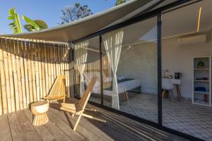 een patio met 2 stoelen en een bed op een terras bij 7 Dreams Glamping #5 in Kubupenlokan