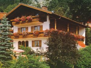 ein Haus mit Blumenkästen auf dem Balkon in der Unterkunft Ferienwohnungen am Hausberg in Reit im Winkl