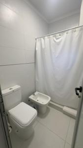 ein weißes Badezimmer mit Toilette und Waschbecken in der Unterkunft Moderno con vistas al Río in Pueblo Esther