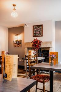 een restaurant met tafels en stoelen en een open haard bij The Railway in Skipton +1 foto