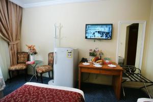 a room with a table and a refrigerator in it at فندق قصر الأزهر - Al-Azhar Palace Hotel in Mecca