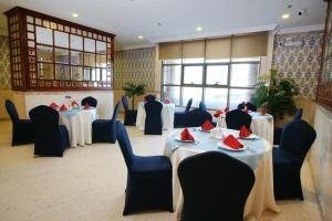 a dining room with tables and chairs with red napkins on them at فندق قصر الأزهر - Al-Azhar Palace Hotel in Mecca