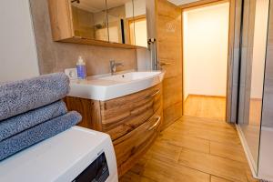 een badkamer met een wastafel en een spiegel bij FEWO 2 zur schönen Aussicht in Hinterschmiding +26 foto's